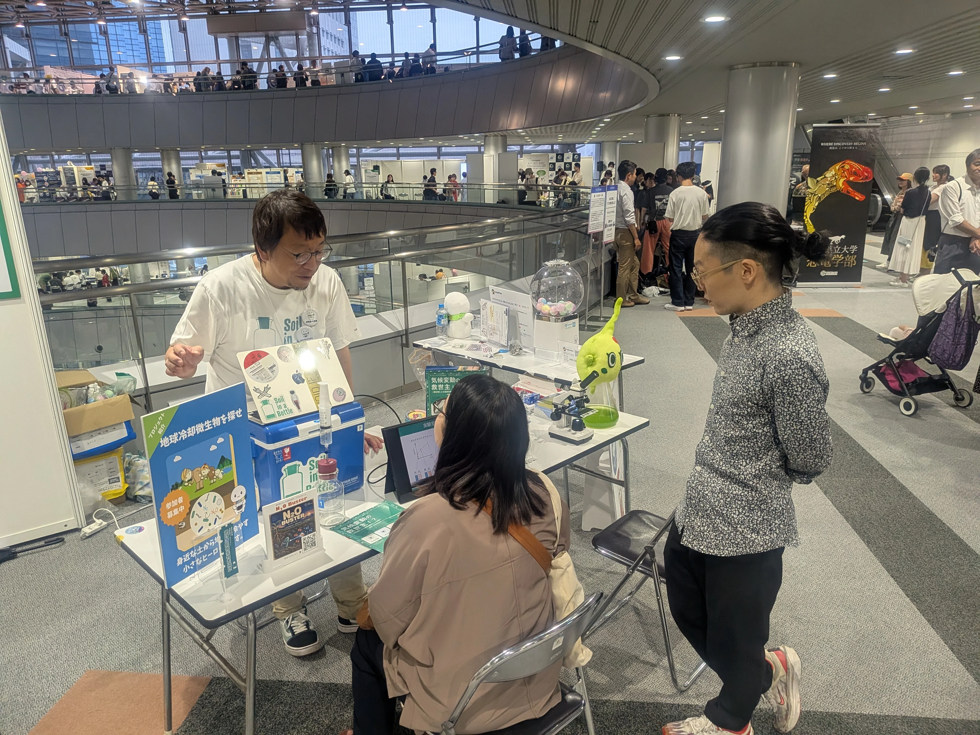 地球冷却微生物を探せの研究者が来場者に説明している様子